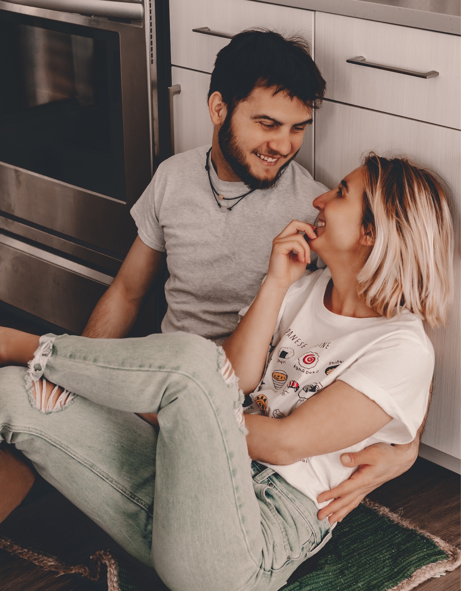 Couple sitting on kitchen floor laughing